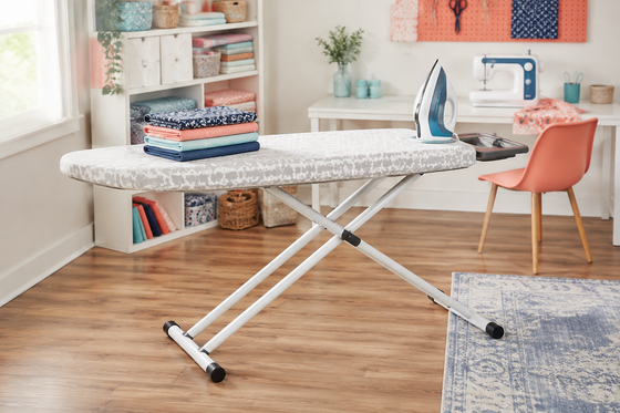 Full-size ironing board in a bright sewing room