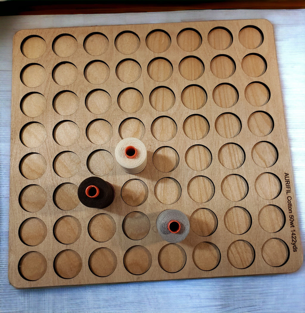 Aurifil Unnumbered Thread Storage Tray, 64 Spools — overhead view with four sample spools
