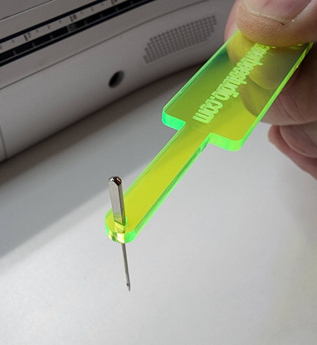Needle insertion tool holding a flat-backed machine needle during a needle change