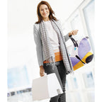 Woman holding a colorful bag and shopping bags with a blurred indoor background
