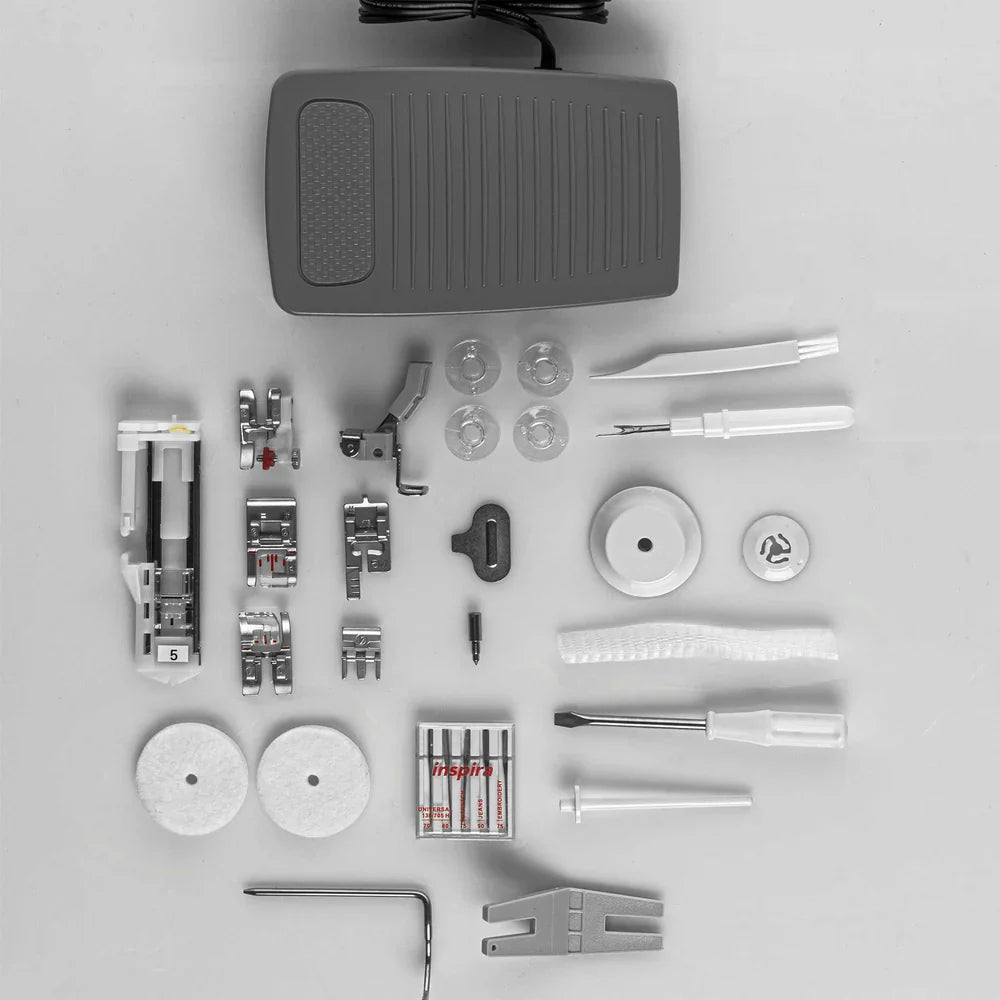 Collection of sewing machine parts and accessories on a gray background