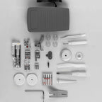 Collection of sewing machine parts and accessories on a gray background
