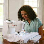 SINGER SE9180 embroidery machine in use creating detailed embroidery design on fabric with large embroidery hoop attached