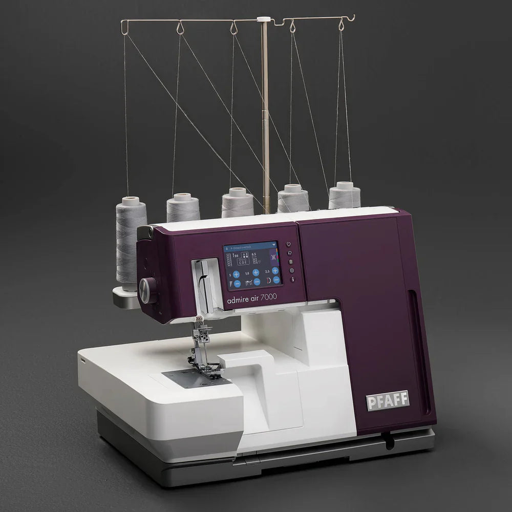Sewing machine with multiple spools of thread on a dark background