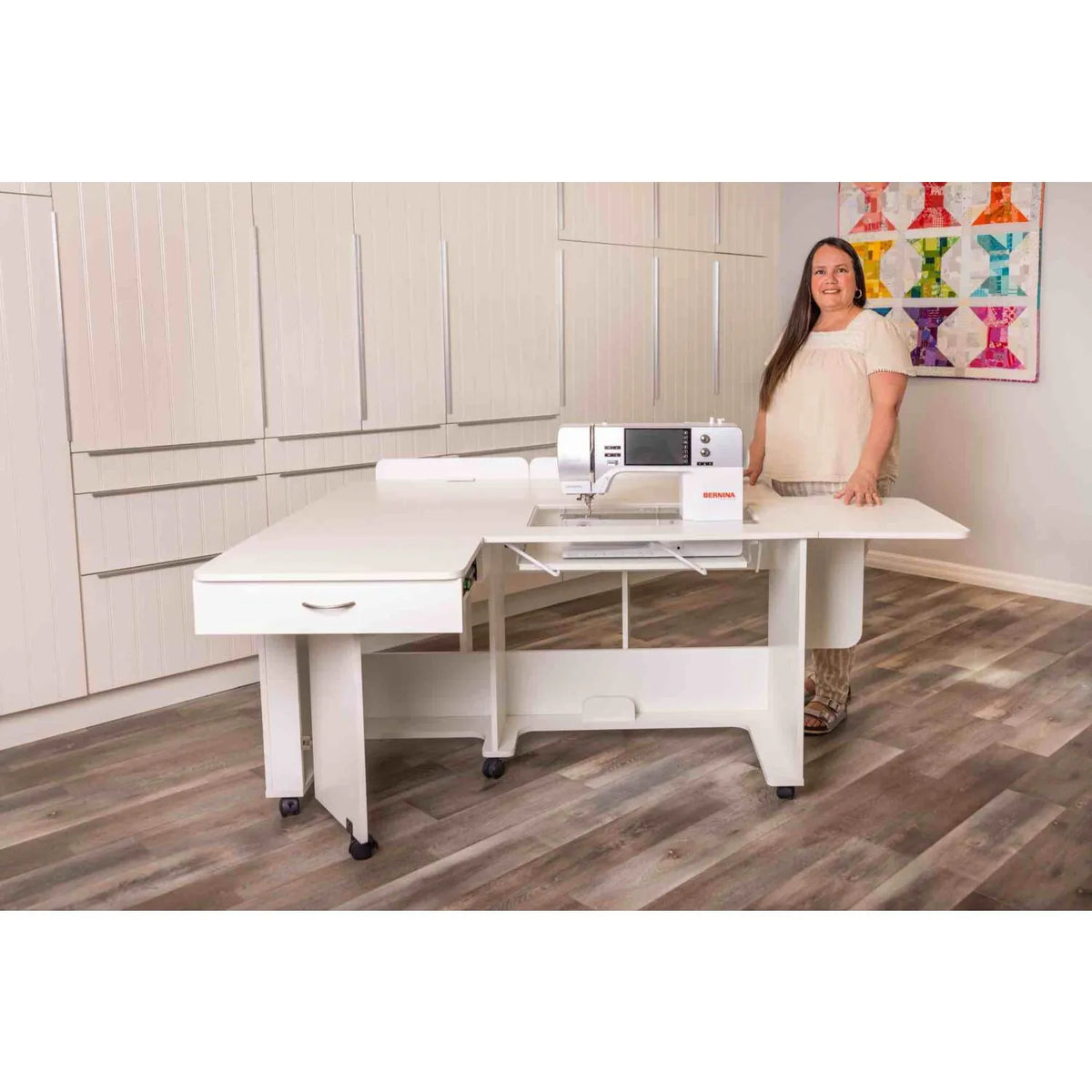 Arrow Christa Sewing Cabinet in White fully extended with sewing machine, demonstrated by sewist in modern studio.