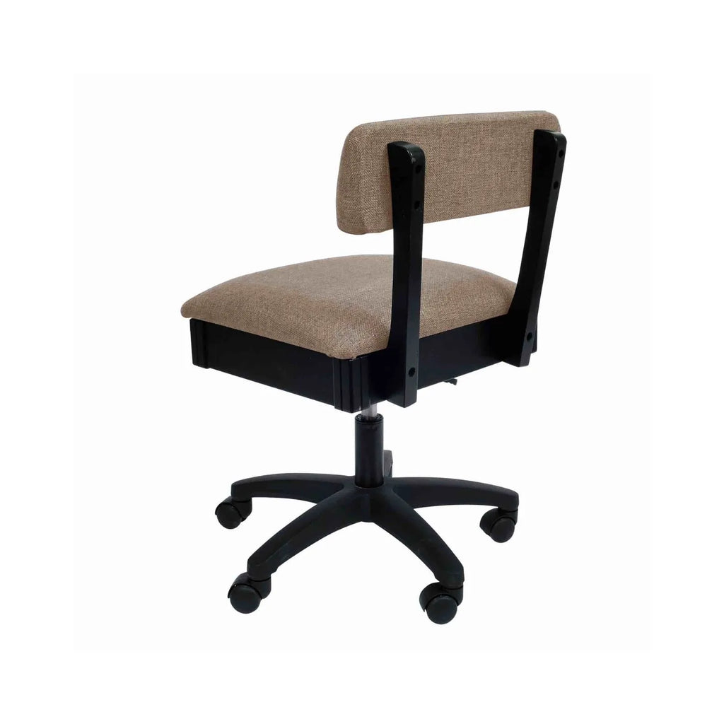 Arrow Princess Hazel Hydraulic Sewing Chair – rear angle view showing supportive backrest, woven tan fabric upholstery, and smooth-rolling caster wheels.