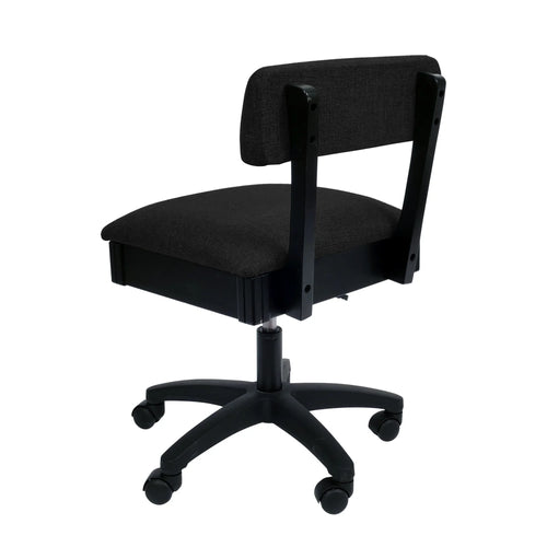 Arrow Baroness Black Hydraulic Sewing Chair – rear angle view showing black woven fabric upholstery, supportive backrest, and smooth-rolling caster wheels.