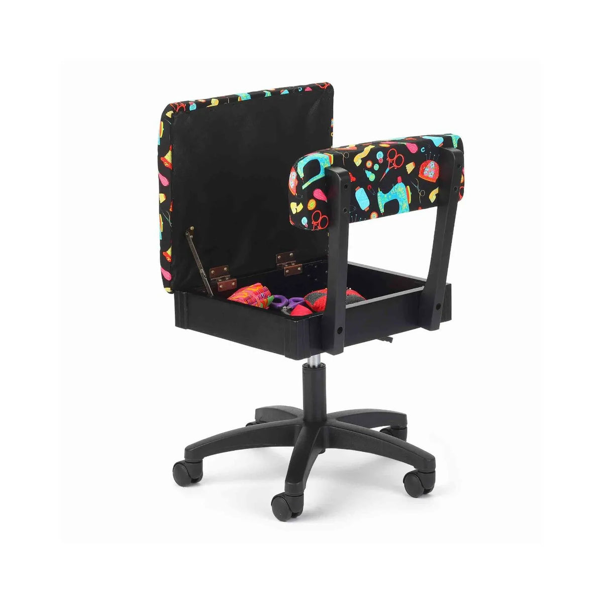 Arrow Black Notions Hydraulic Sewing Chair – open seat storage compartment with sewing tools inside, featuring colorful print upholstery on a black background.