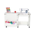 Arrow Judy Sewing Cabinet 101 in White with sewing machine installed, extended workspace, and storage cubby filled with colorful thread and fabric.