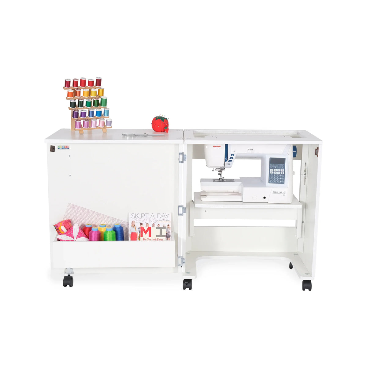 Arrow Judy 101 White Sewing Cabinet showing hydraulic lift in flat-bed position with Janome sewing machine and organized thread display.