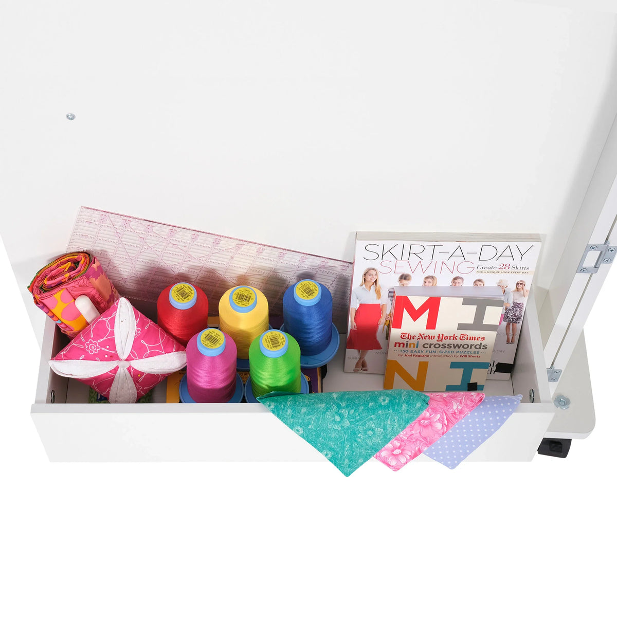 Close-up of Arrow Judy Sewing Cabinet 101 storage cubby filled with multicolored thread spools, fabric pieces, and sewing accessories.