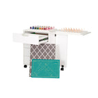 Arrow cabinet drawer unit extended with fabric storage and cutting mat pulled out for sewing organization.