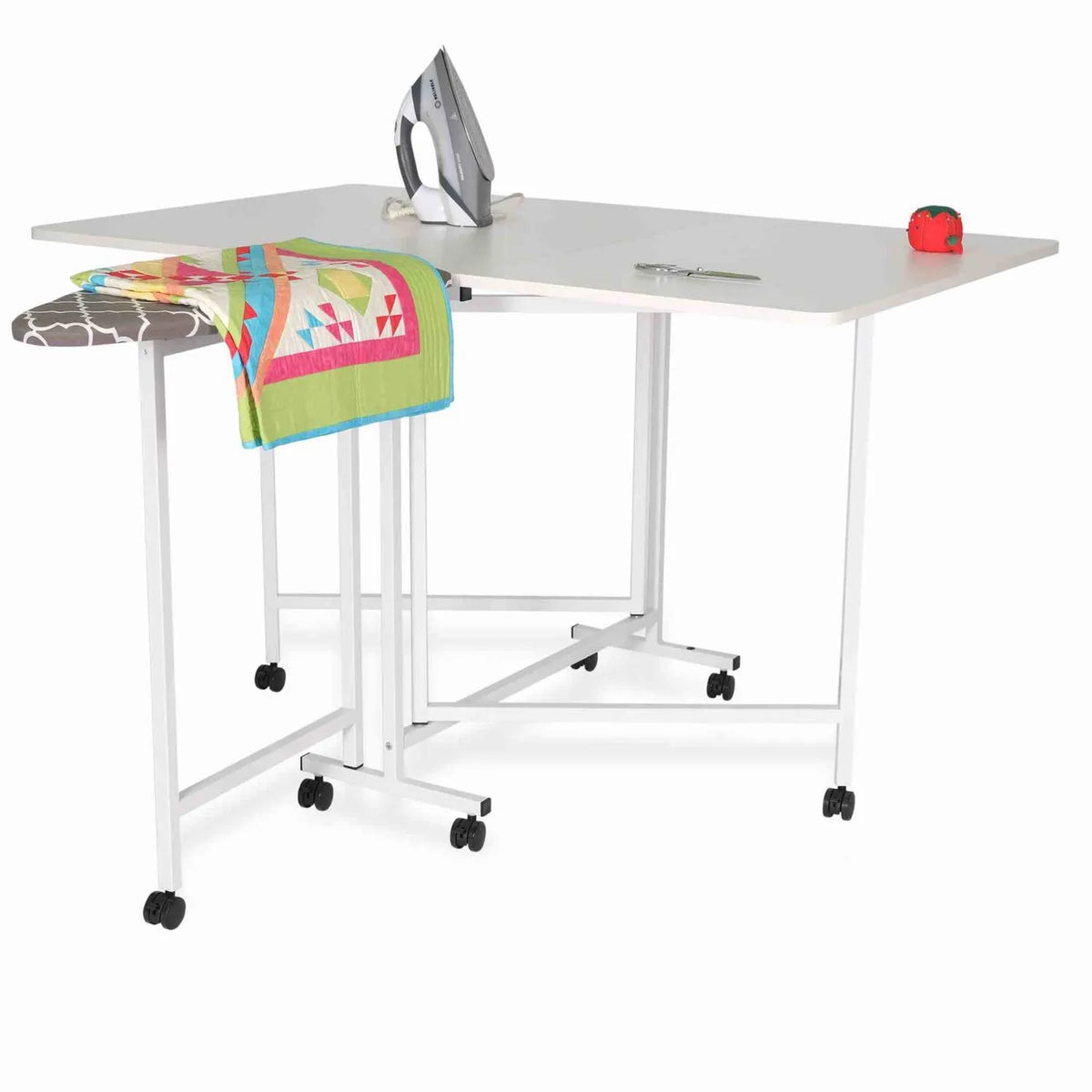 Arrow Millie 3311 cutting and ironing station in use with iron, quilt fabric, and accessories displayed on extended work surface.