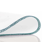 White towel with green lace trim on a white background