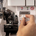 Hand operating a sewing machine with close-up details