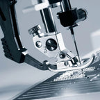 Close-up of a sewing machine needle and presser foot on a blurred background