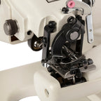 Close-up of the Consew 75T needle, presser foot, and blindstitch mechanism.