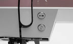 Close-up of a sewing machine with control buttons on a white background