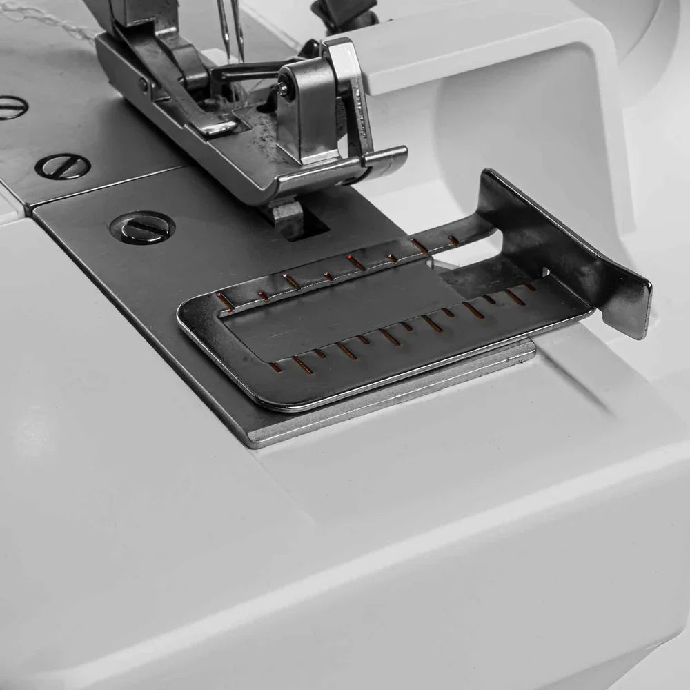 Close-up of a sewing machine needle plate with a white background