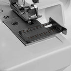 Close-up of a sewing machine needle plate with a white background