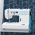 White and blue sewing machine on a glass surface with a patterned blue background