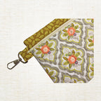 Floral in-the-hoop zippered bag with an optional fabric tab and swivel clasp hardware