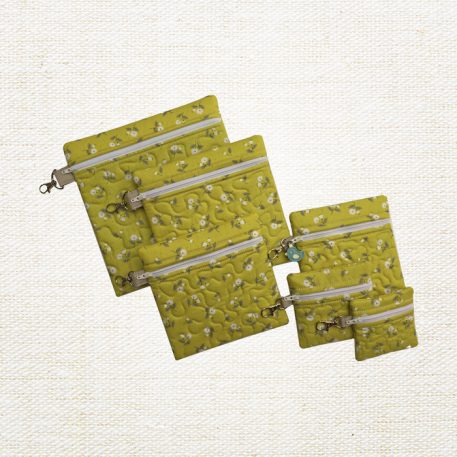 Set of six green quilted in-the-hoop zippered bags in graduated square sizes