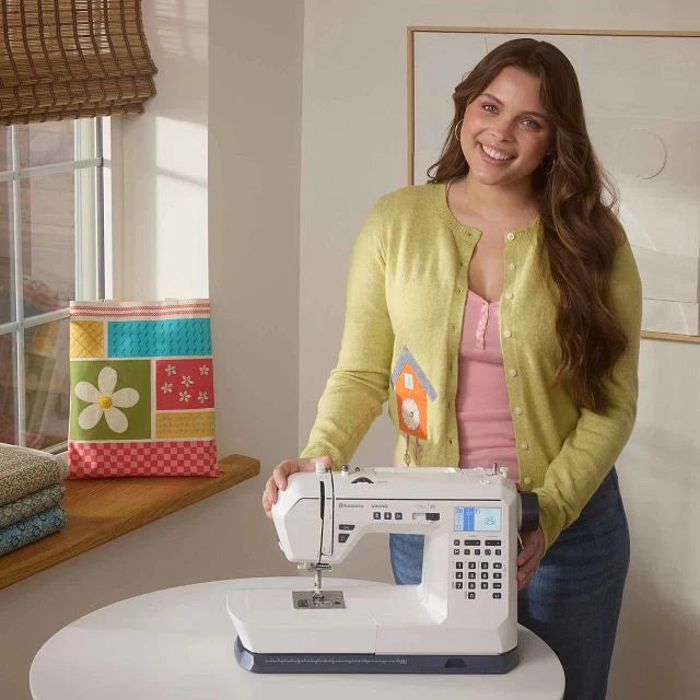 Woman using Husqvarna Viking Onyx 30 computerized sewing machine in a home sewing room for creative sewing projects
