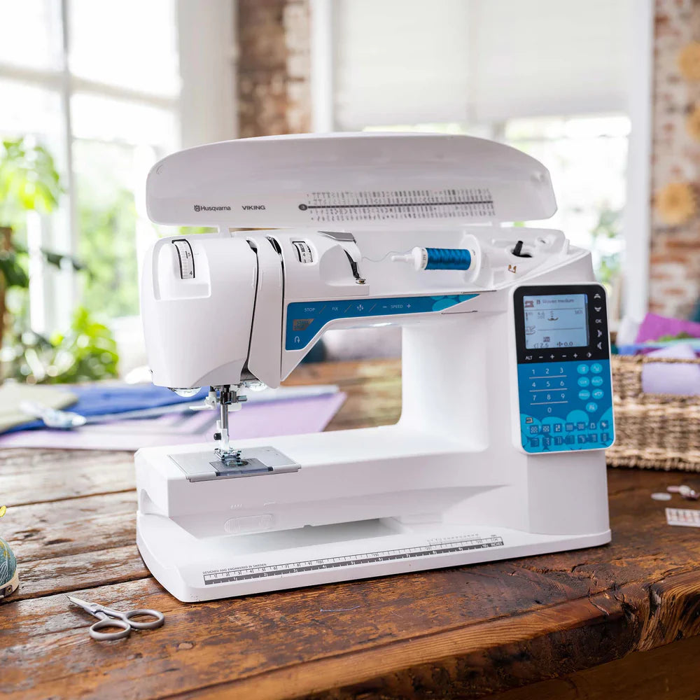 Husqvarna Viking Opal 650 sewing machine with top cover open showing bobbin winding system and internal threading path