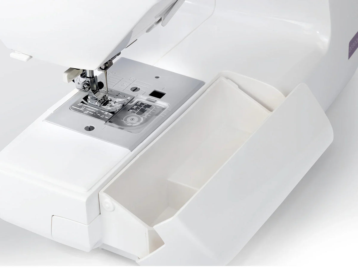 Removable storage compartment on the Janome 2030DC-G sewing machine designed to hold accessories and tools.