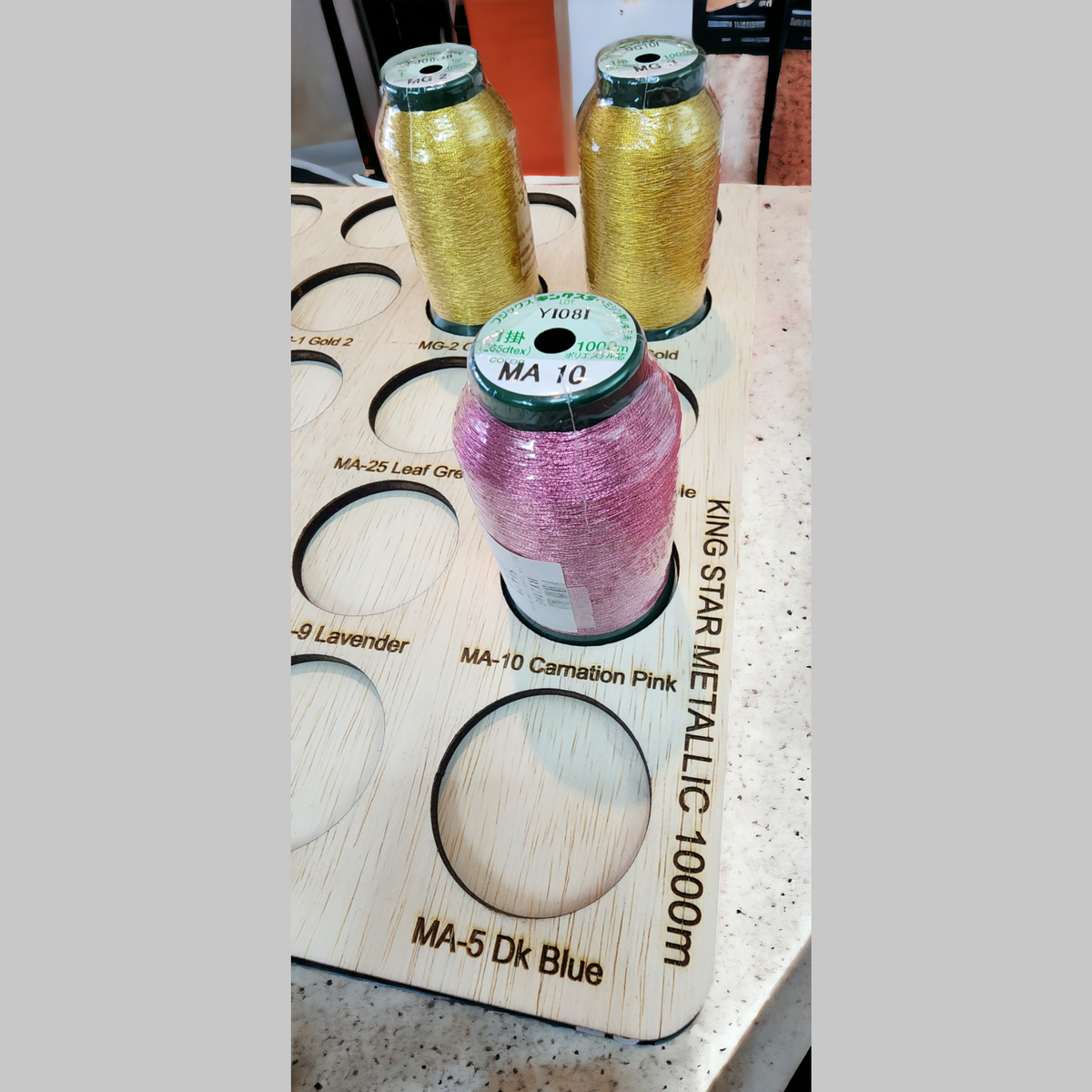Kingstar Metallic Thread Storage Tray, 25 Spools — close-up of gold and purple metallic spools in the tray