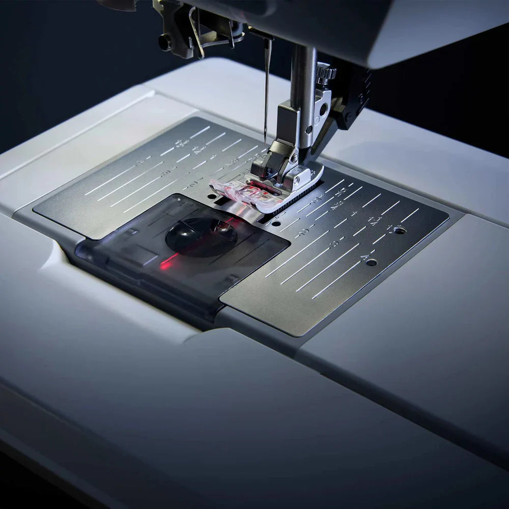 Sewing machine with needle and presser foot on a dark background