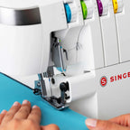 SINGER SE017 Elite overlock machine finishing fabric edge with professional serger stitch and color-coded tension dials