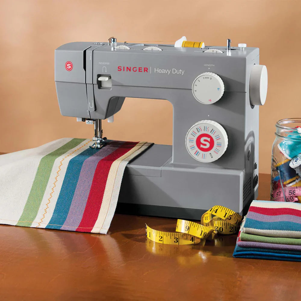 SINGER 4432 Heavy Duty sewing machine in use sewing colorful fabric on tabletop workspace