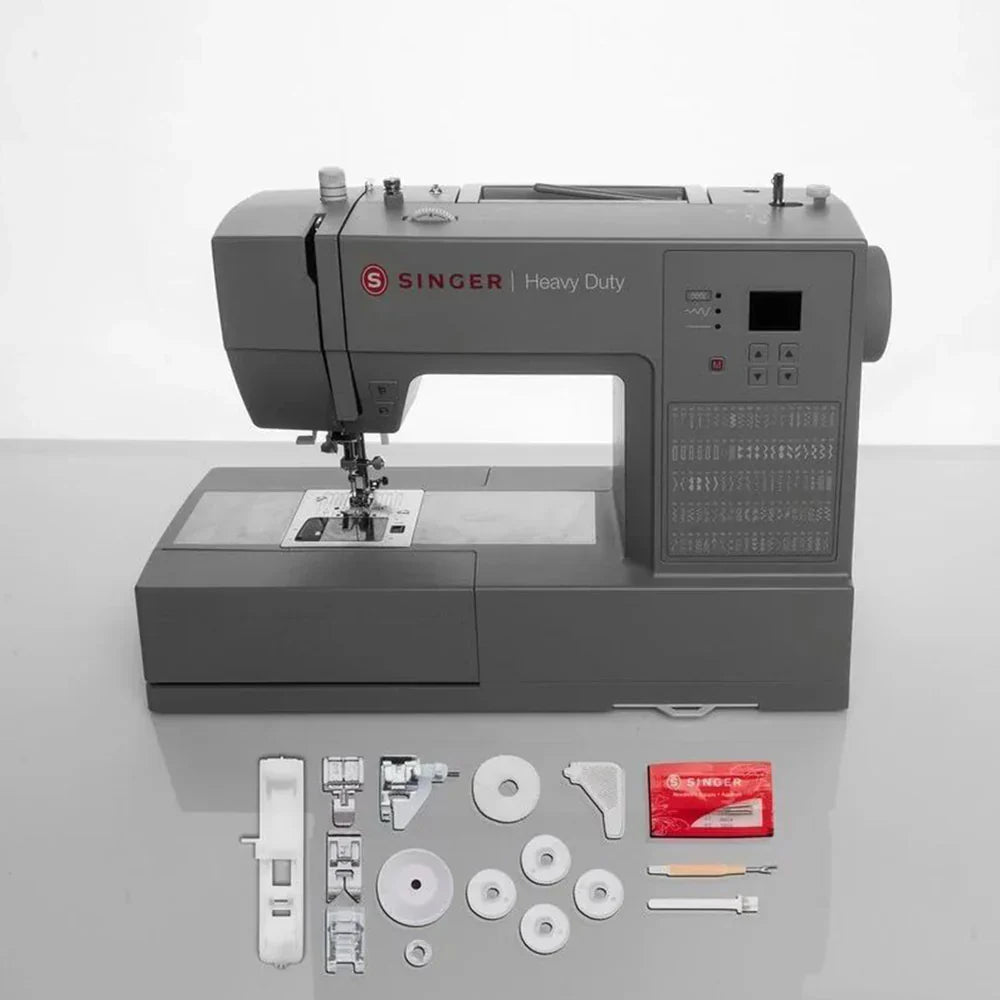 SINGER Heavy Duty 6600C sewing machine with included accessories, presser feet, bobbins, and tools displayed