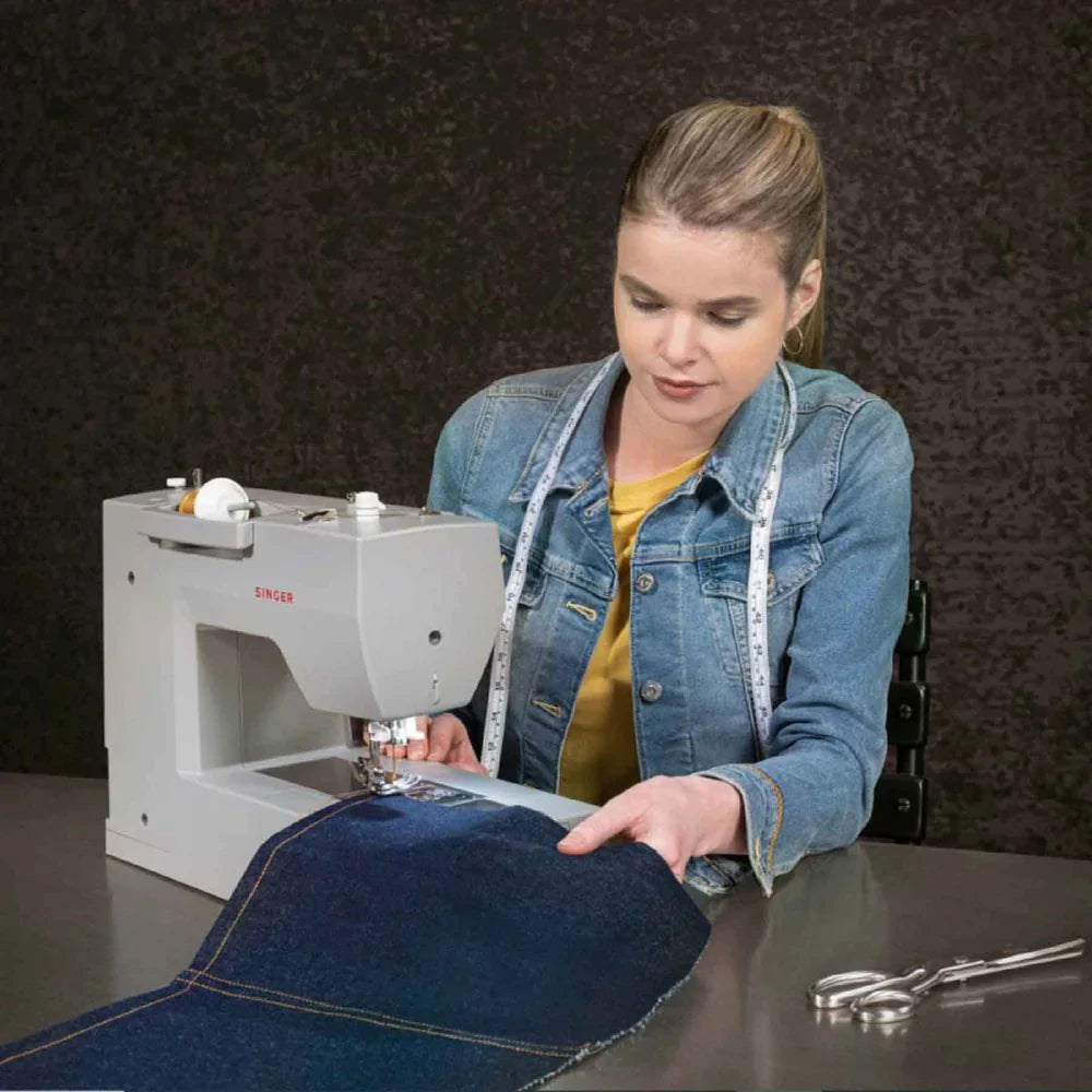SINGER Heavy Duty 6700C sewing machine sewing denim fabric, demonstrating power and precision on thick materials