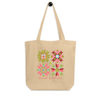 Front of the Merry & Bright Floral Cheer tote hanging by its straps, with four quilt stars above the holiday greeting.