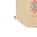 Close-up of the Merry & Bright Floral Cheer tote's quilt-star print, woven fabric and certified-organic side label.