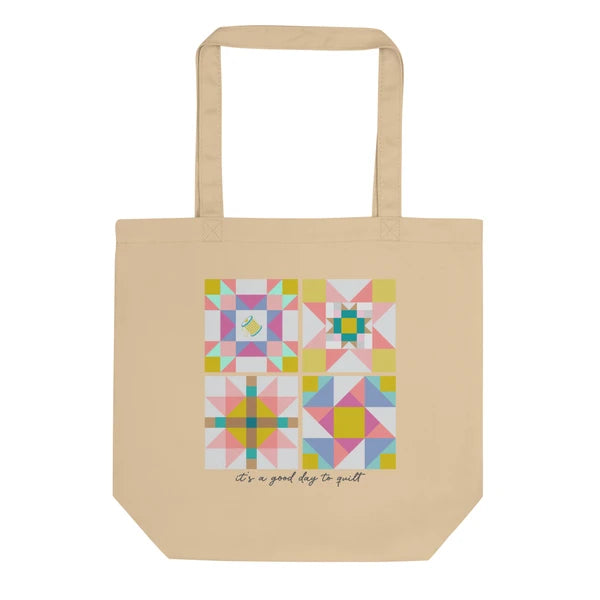Natural-color Pastel 1 tote with a square patchwork print in pink, blue, green and yellow above It's a good day to quilt lettering.
