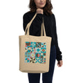 Model carrying a natural-color tote with retro geometric quilt blocks in teal, brown and cream.