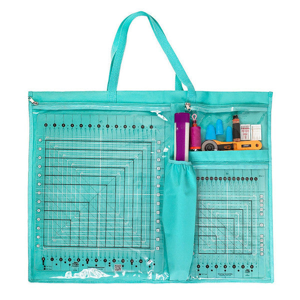Front of a teal ToteOlogy tool bag with clear pockets holding quilting rulers, scissors and other sewing tools.