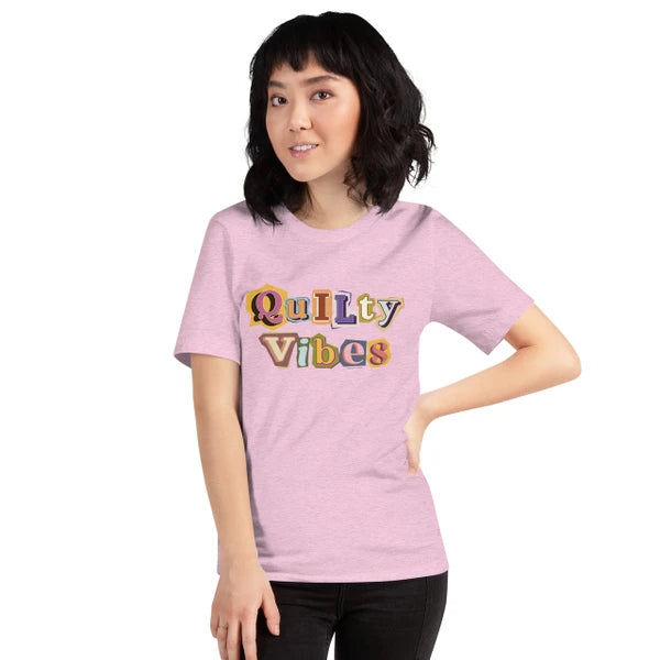 Model wearing the Heather Prism Lilac Quilty Vibes T-shirt with multicolored retro lettering across the chest.