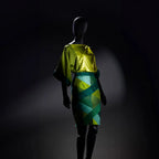 Mannequin wearing a green and yellow dress against a dark background