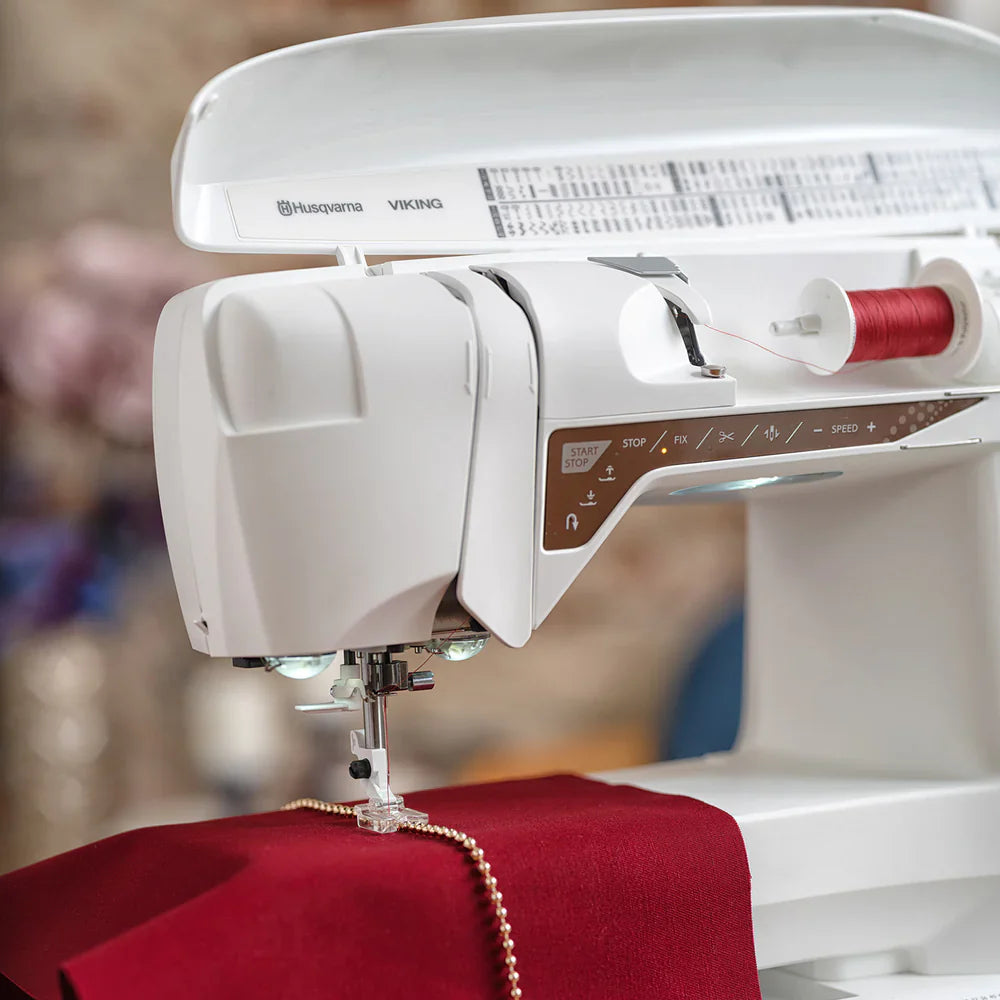 Top view of Husqvarna Viking Designer Topaz 40 sewing machine with open thread compartment and spool holder
