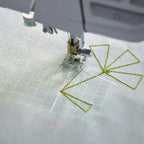 Sewing projection grid and stitch placement guide displayed on fabric while quilting with the EPIC QUILT 97 sewing machine