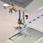 Detailed view of presser foot and needle stitching decorative quilting patterns on the Husqvarna Viking EPIC QUILT 97