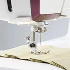 Close-up of Husqvarna Viking Designer Topaz 65 presser foot sewing lightweight fabric with precision stitching