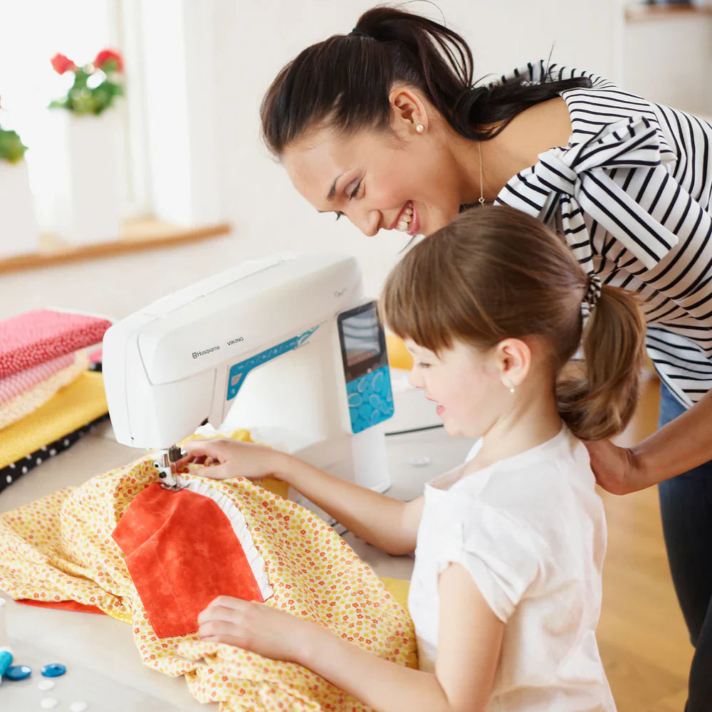 Husqvarna Viking Opal 670 sewing machine used by a child with adult supervision for creative sewing projects
