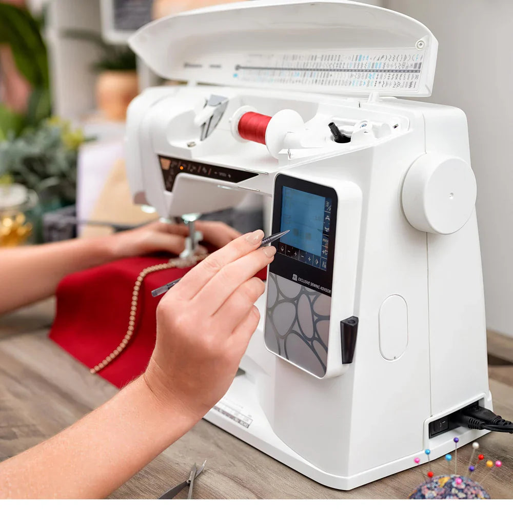 Side view of Husqvarna Viking Opal 690Q sewing machine with user adjusting touchscreen controls during sewing project