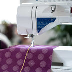 Close-up of Husqvarna Viking Sapphire 930 sewing machine needle area sewing decorative stitch on patterned fabric